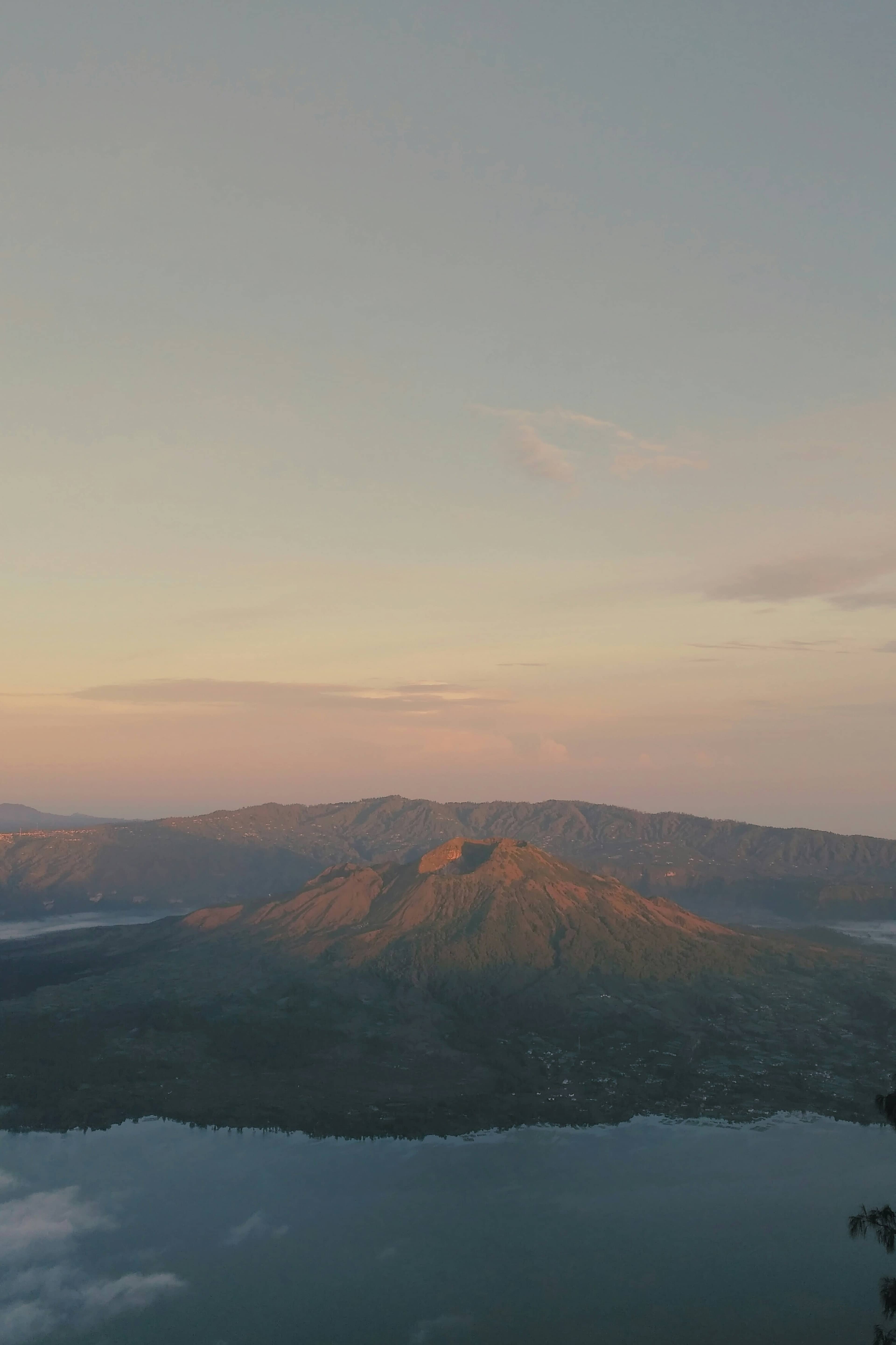 Mount Batur volcano at sunrise, Kintamani, Bali, golden light over volcanic terrain