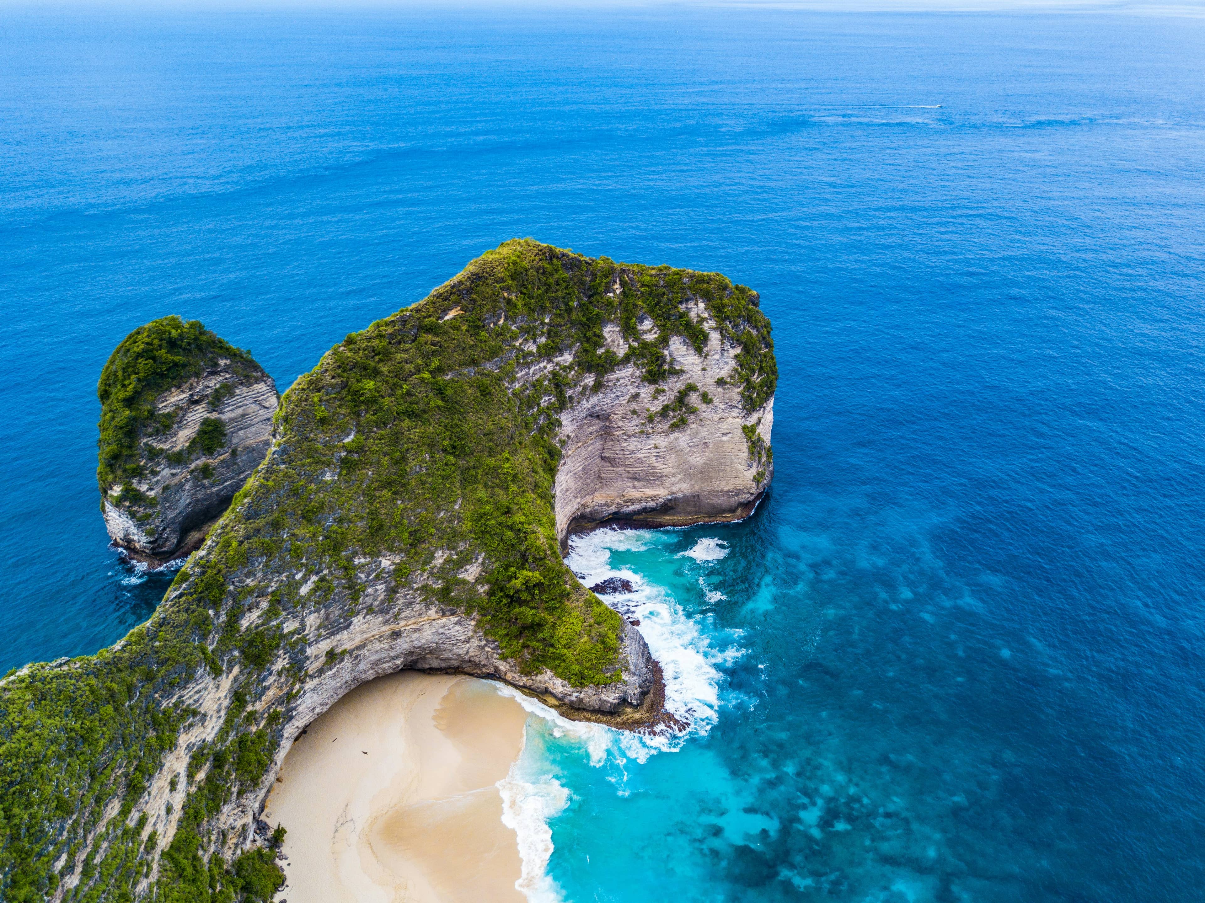 Kelingking Beach's T-rex-shaped cliff formation, Nusa Penida, Bali, aerial view over turquoise water