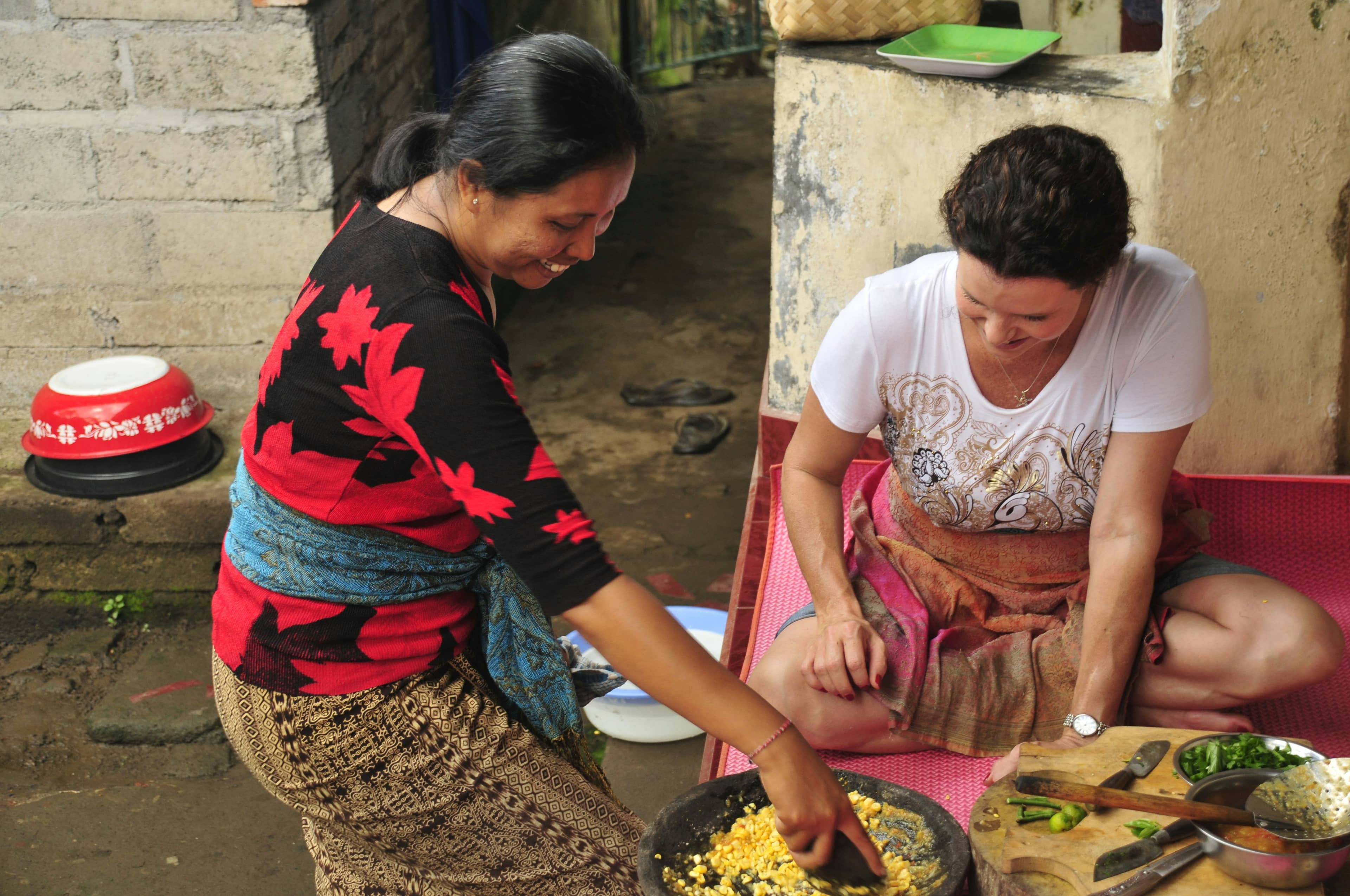 Two people preparing food together in a Balinese cooking class