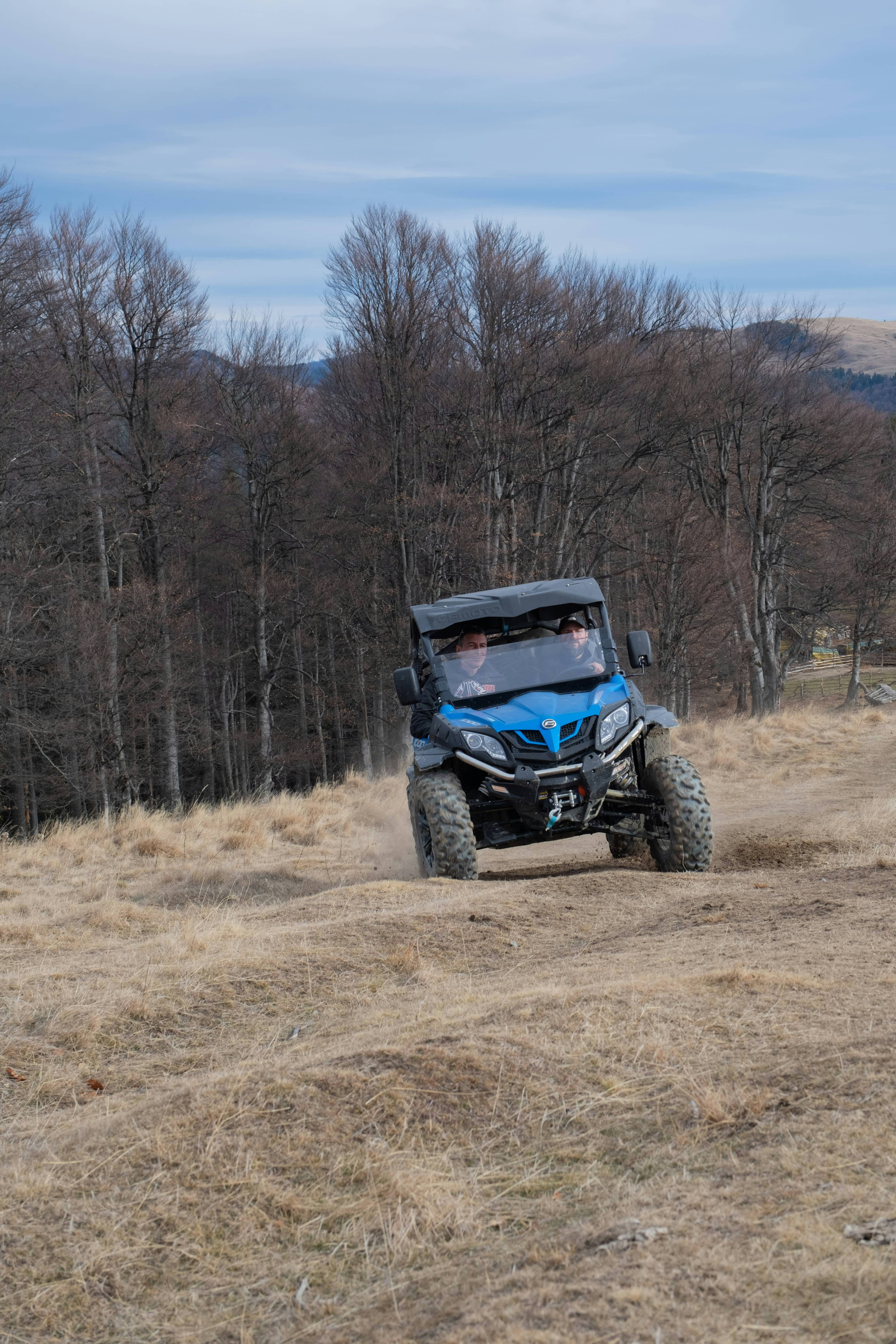 Person riding a buggy on a dirt road through rugged terrain