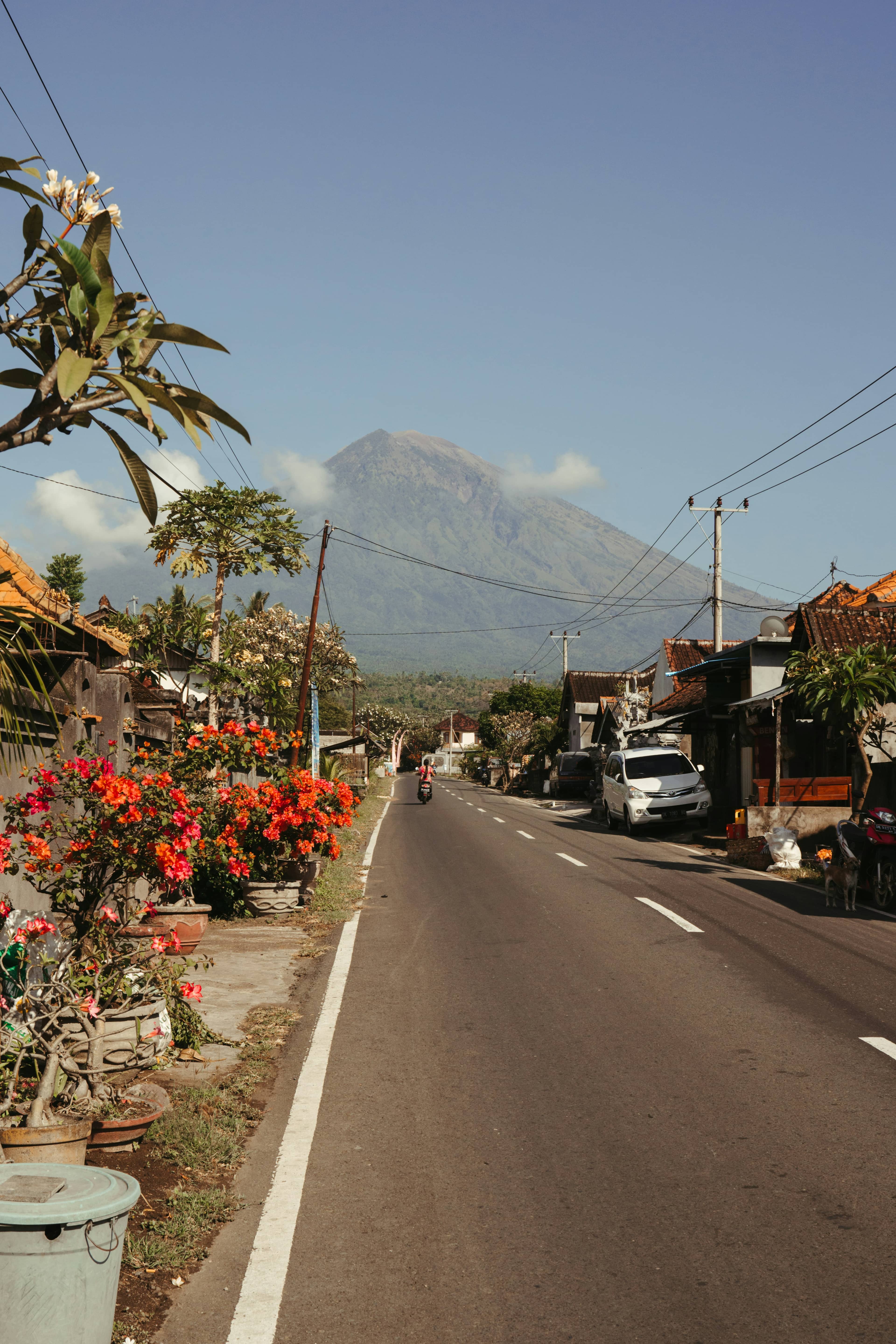 A quiet Bali street with a mountain in the background